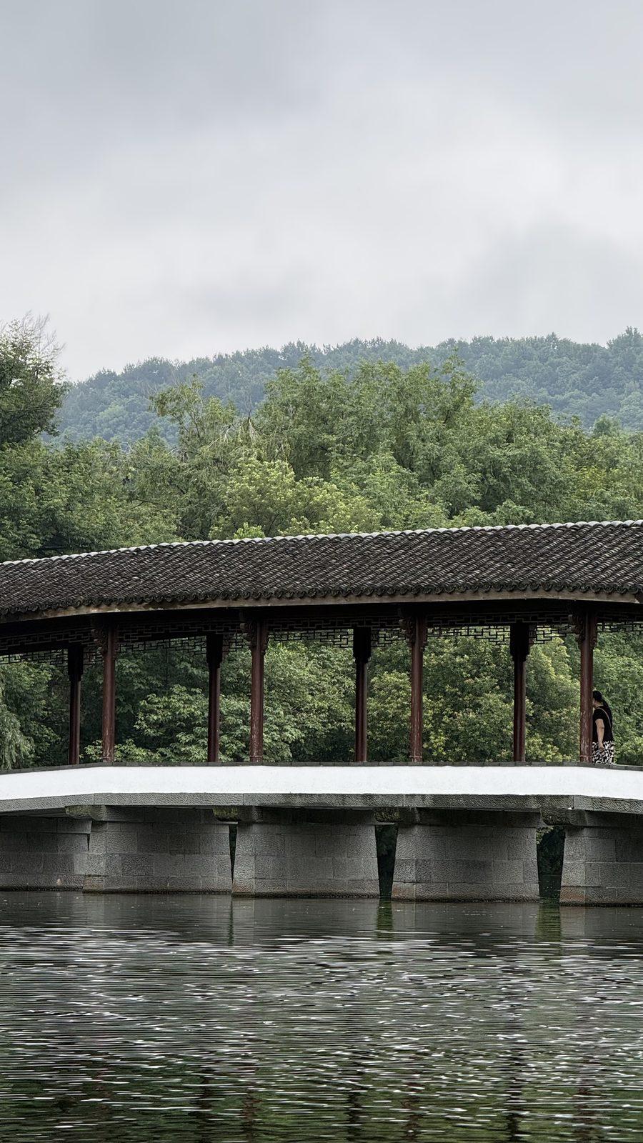 A covered timber bridge over the water on the western side of West Lake, Hangzhou