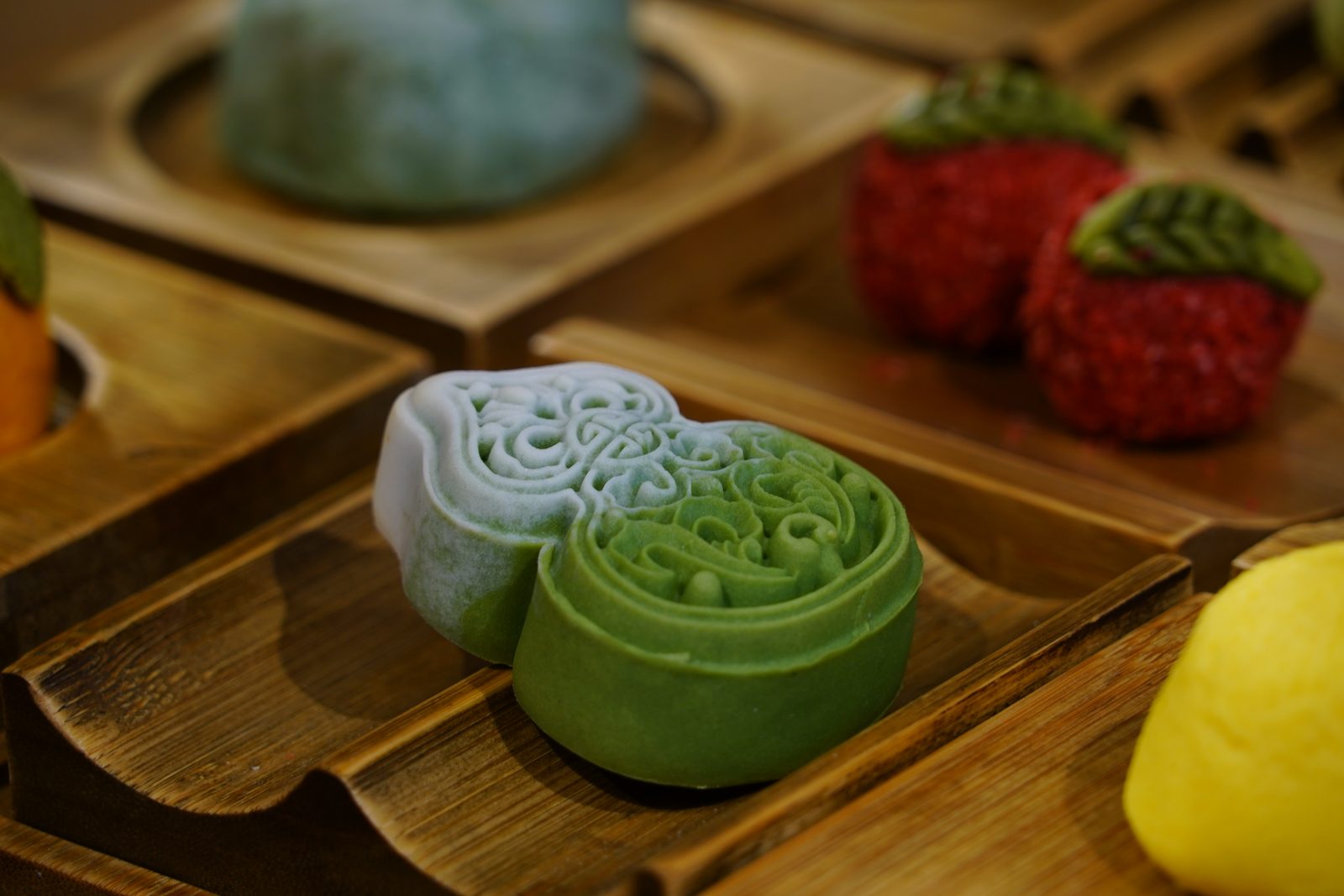 Moulded pastries in tea green and pale blue on a wooden tray, Qinghefang, Hangzhou