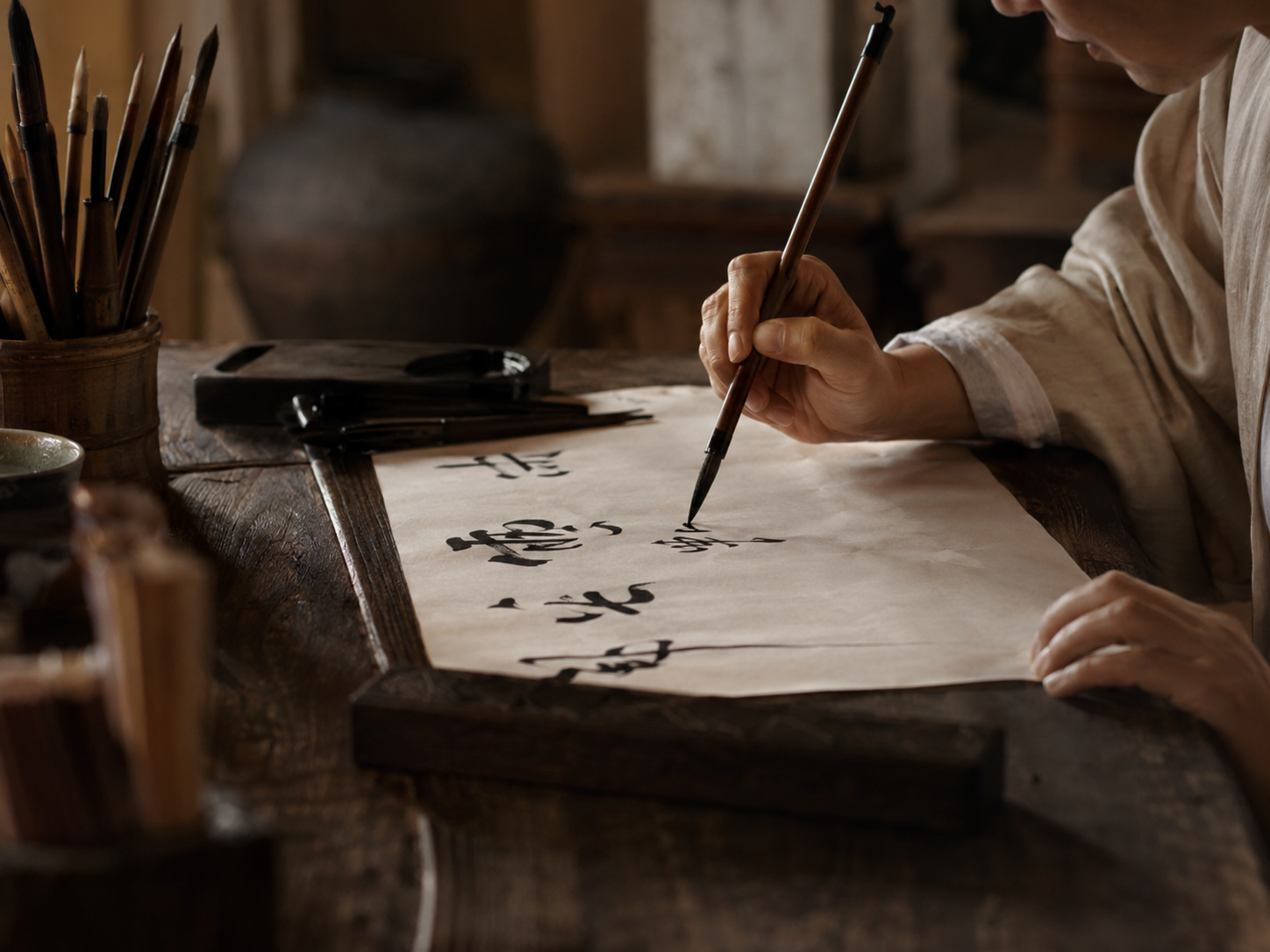 A calligrapher's hand and brush over paper